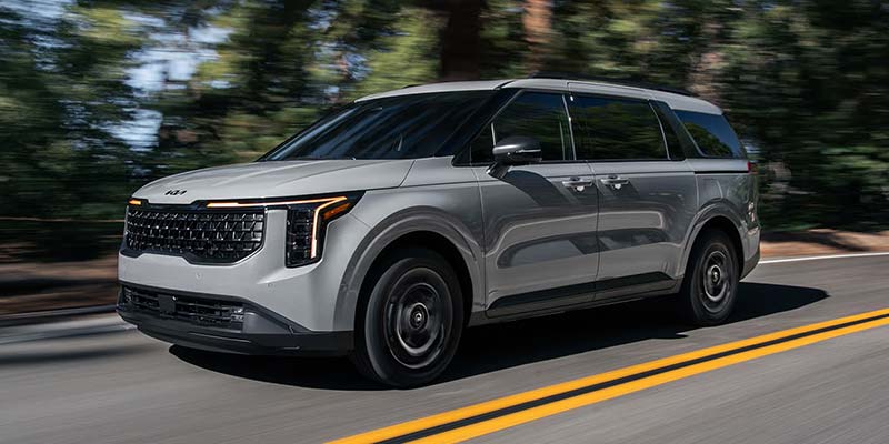 2026 Kia Carnival Hybrid parked outdoors showcasing its bold SUV-inspired profile