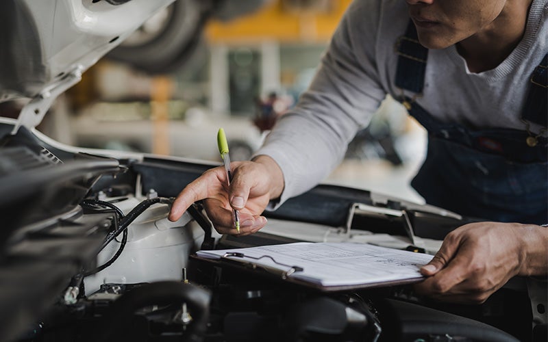 Certified Pre-Owned Kia technician inspecting a vehicle at Cable Dahmer Kia of Lawrence