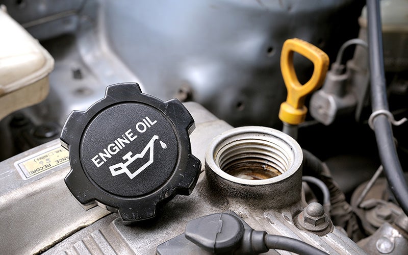 Technician checking engine oil level with a dipstick